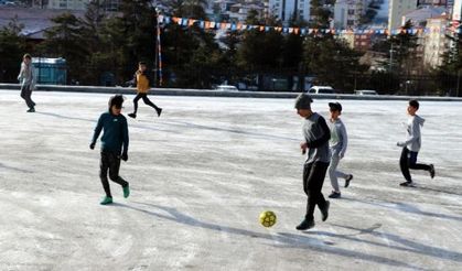 Öğrencilerin buzlu zeminde futbol keyfi